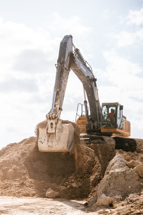 Excavator digging a trench on a house job, photo stamped with the time and GPS